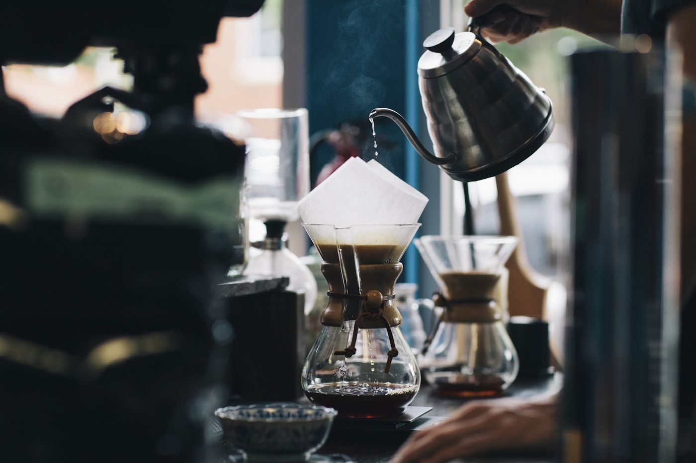 Freshly roasted coffee beans, glossy and dark, spilling across a steel cooling tray.